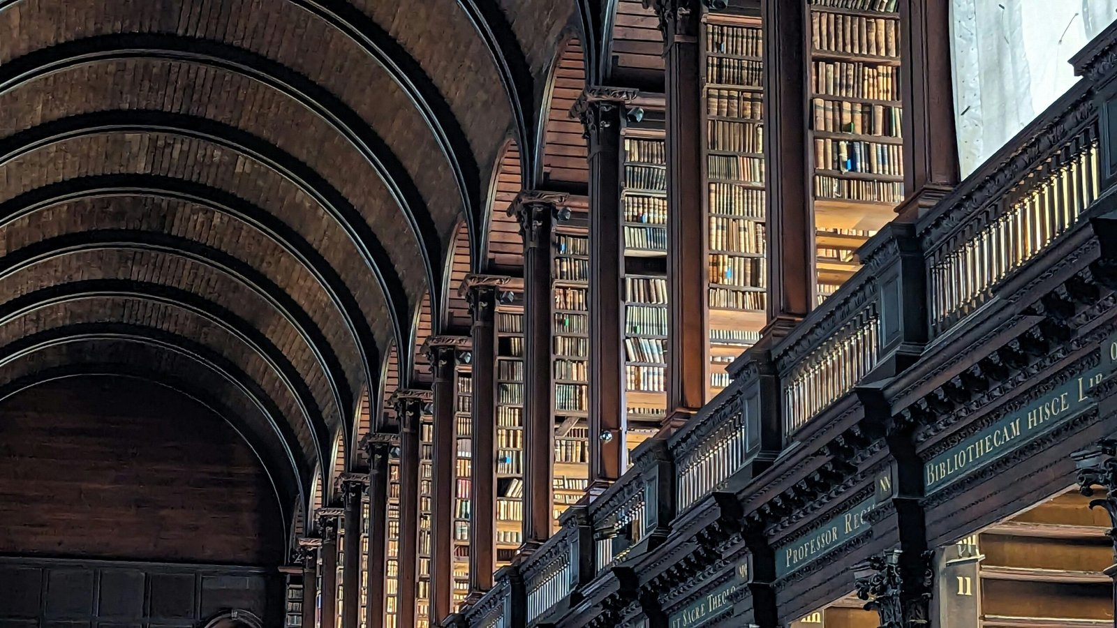 A long row of wooden bookshelves in a library